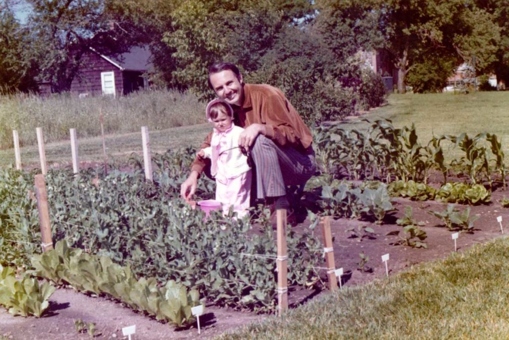 photographer from Robin Collette Photography as a toddler in the garden with her father