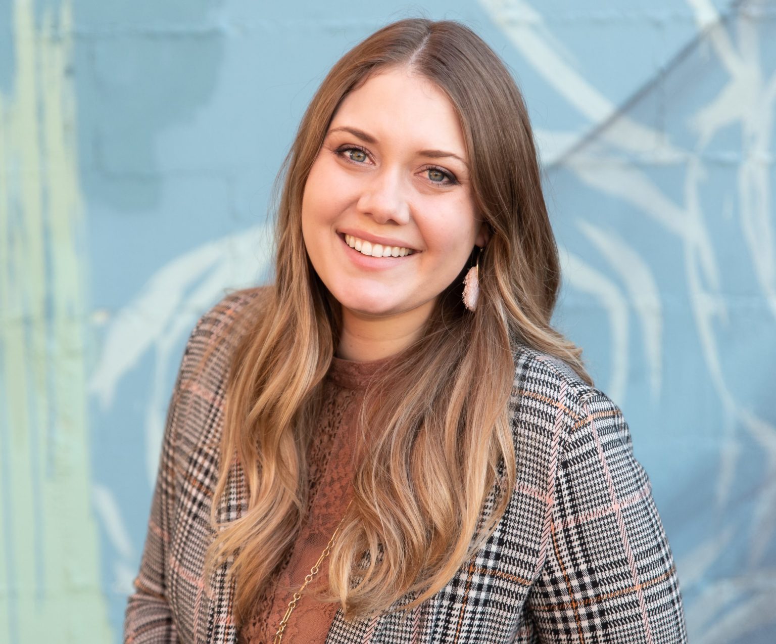 A woman posing for her headshot against an abstract headshot background